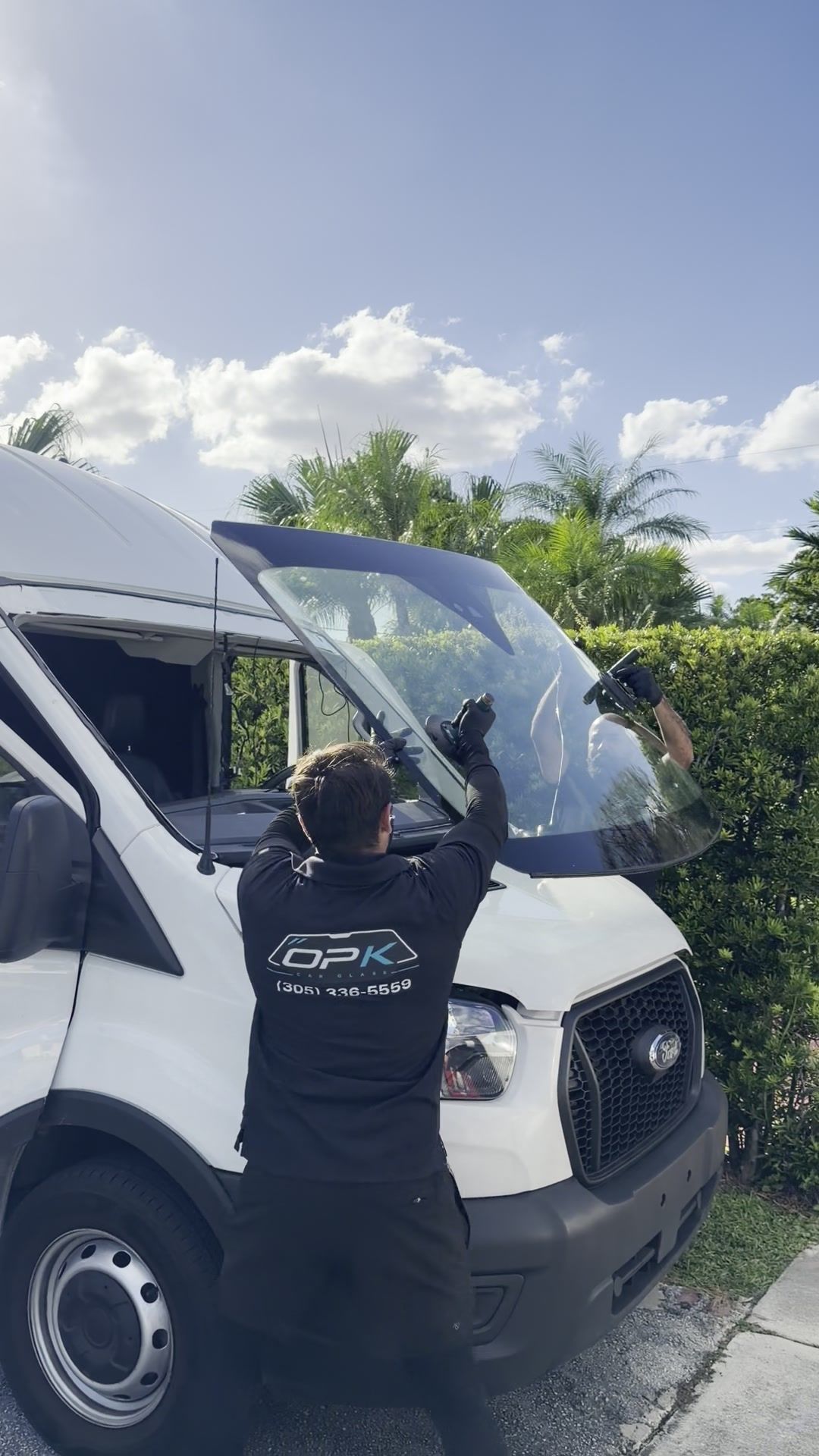 Setting the new windshield into place on the van