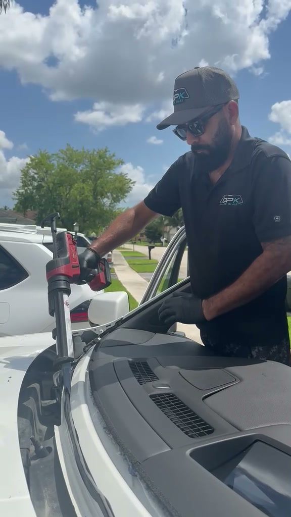 Technician laying urethane on the GMC Yukon windshield frame