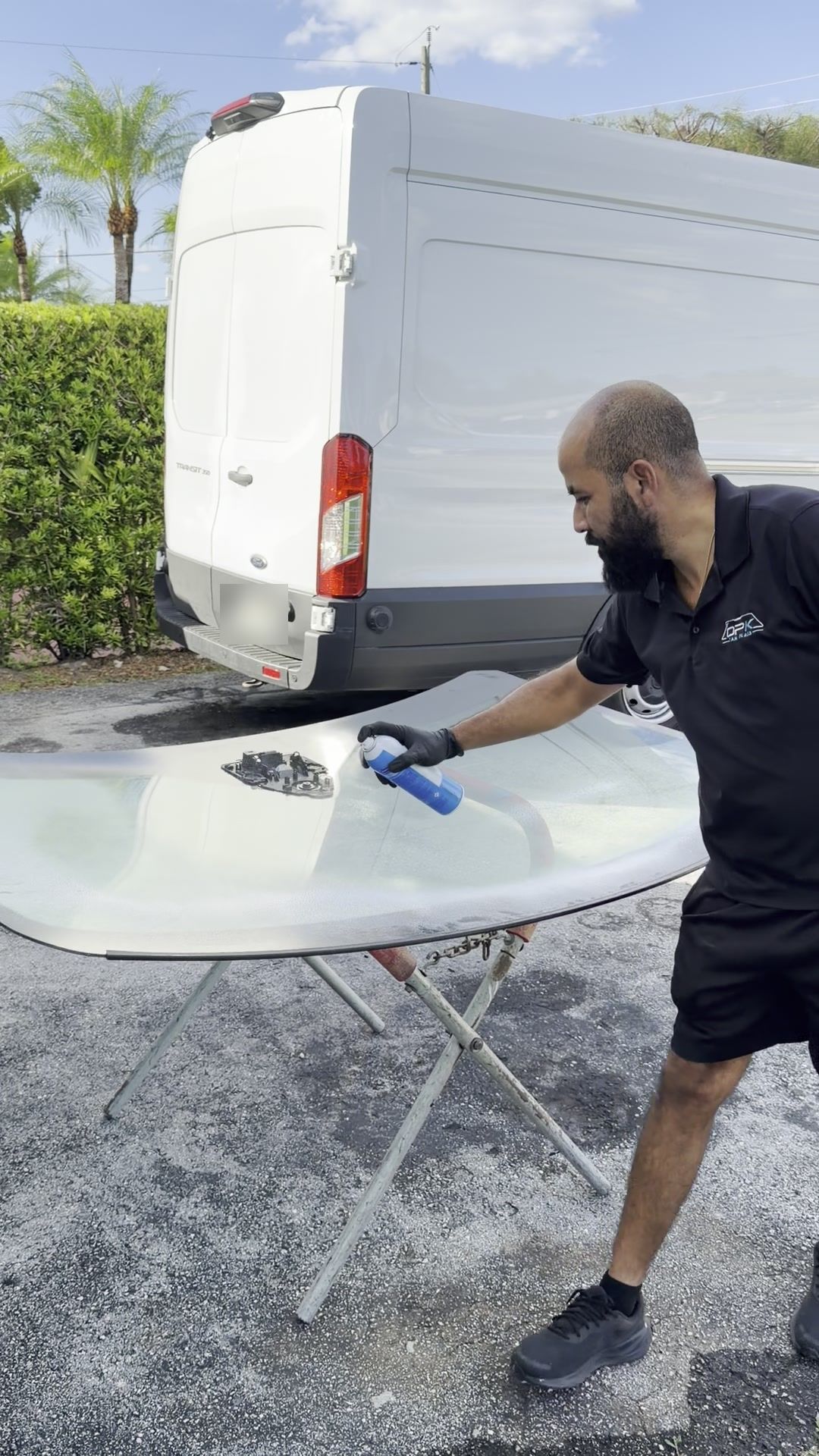 Technician cleaning the new windshield on a stand