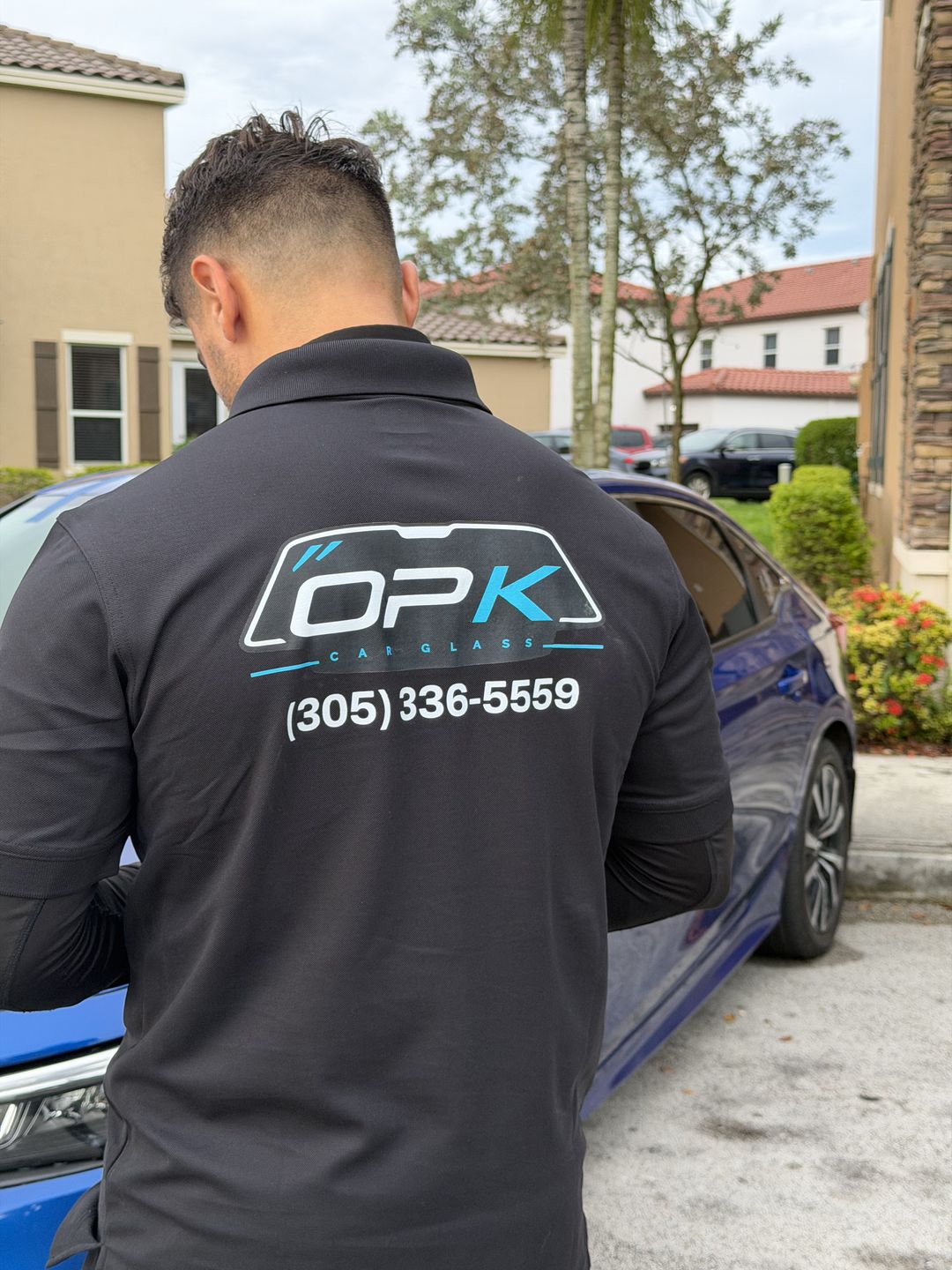 OPK technician in a branded jacket at a customer's car